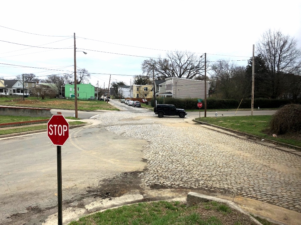 Stop sign at a wide cobblestone intersection at 22nd and Carrington