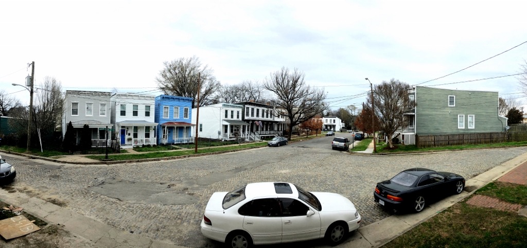 Panorama of the wide intersection of Carrington and 24th Streets, lined with houses